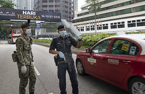 Soldier and police in face masks maintain a checkpoint in Kuala Lumpur, Malaysia, Sunday, March 22, 2020. (Photo | AP)
