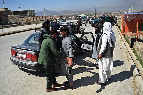 Afghan policeman searches people travelling in a car at a road checkpoint in Kabul. (File photo| AFP)