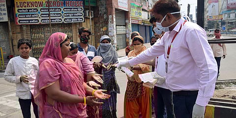 Social activists hand sanitize people, who came out to buy the essentials during the lockdown throughout the country, to contain the spread of coronavirus in Patna. (Photo| ANI)