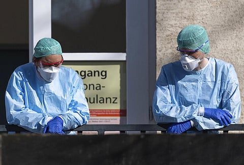 Employees of the Corona Outpatient Clinic at the University Hospital stand in protective clothing and breathing masks in front of the entrance, Dresden, Germany. (Photo | AP)