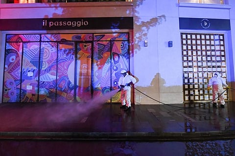 Municipal workers disinfect the streets of the Palm Island in Dubai as a preventive measure against the spread of the novel coronavirus in the Emirate city on March 28, 2020. (Photo | AFP)