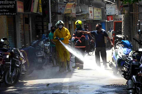 A BMC worker sprays disinfectant at a market to contain the coronavirus during a nationwide lockdown in Mumbai Sunday March 29 2020. (Photo | PTI)