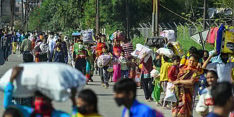 Migrant workers along with their family members walk to their villages, amid a nationwide lockdown in wake of coronavirus pandemic, at Lal Quarter Bus Stand in New Delhi. (Photo| PTI)