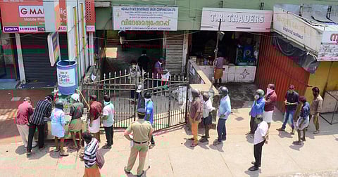 People stand in queue in front of the Beverages outlet to buy liquor fearing the close down in the wake of coronavirus spreading, in Kozhikode. (Photo| Manu R Mavelil, EPS)