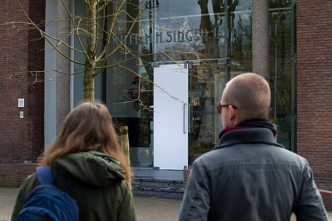 Two people look at the glass door which was smashed during a break-in at the Singer Museum in Laren, Netherlands, Monday March 30, 2020. (Photo | AP)
