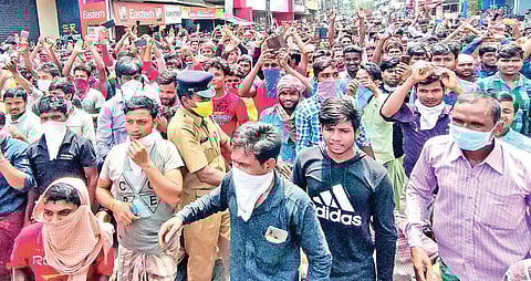 Migrant labourers protest at Payippad Junction near Changanassery on Sunday. (Photo| EPS/Shaji Vettipuram)
