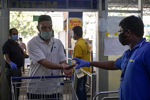 Metro supermarket staff ensuring that people are wearing masks and sanitising their hands before entering the premises.