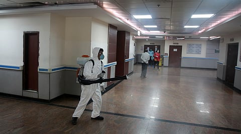 A hospital worker dressed in protective coveralls sprays disinfectants at Safdarjung Hospital in New Delhi as a precautionary measure to contain COVID-19. (Photo | Shekhar Yadav, EPS)