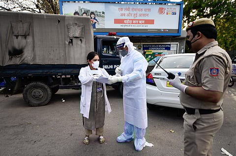 Medics, in protective suits, interact as police cordon off an area in Nizamuddin after some people showed coronavirus symptoms, in New Delhi. (Photo | PTI)