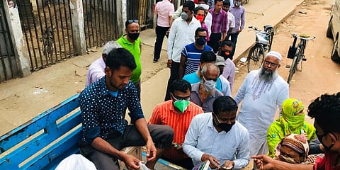 People line up to shop for essential items from a roadside truck in Dhaka, Bangladesh. (Photo | AP)