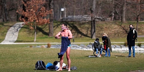 A man wearing a scarf uses a towel after taking a swim in a park in Prague, Czech Republic. (Photo | AP)