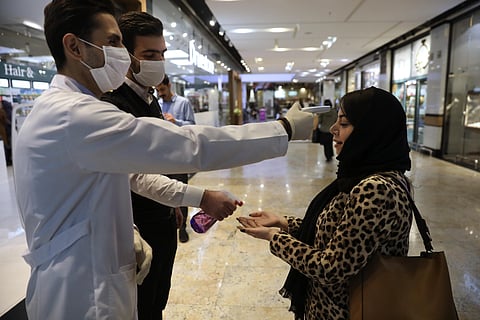 A woman has her temperature checked and her hands disinfected as she enters the Palladium Shopping Center, in northern Tehran, Iran, Tuesday, March 3, 2020. (Photo | AP)