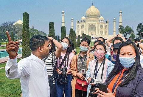 Tourists with protective masks at the Taj Mahal in Agra on Tuesday, while their careless guide goes without a mask despite the coronavirus spread. (Photo | PTI)