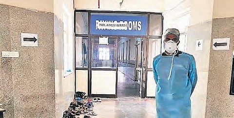 A man in protective gear outside the isolation ward at Gandhi Hospital