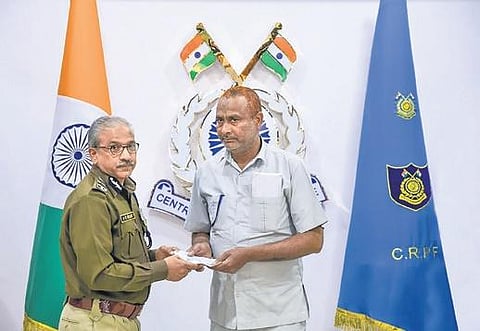 DG CRPF AP Maheshwari, presents a cheque to former CRPF officer Aish Mohammad. (Photo | PTI)