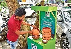 A volunteer of Oneness NGO filling a earthen bowl with water to feed the birds  Albin Mathew