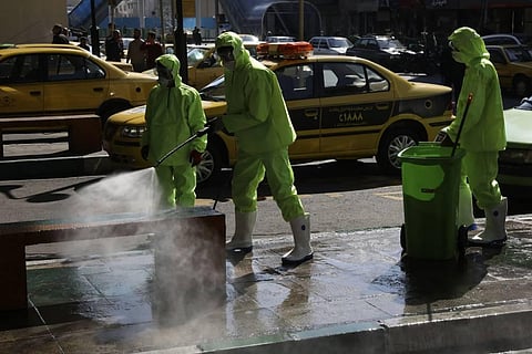 City workers disinfect a bench because of the new coronavirus in Tehran.  (Photo | AP)