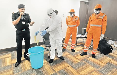 AAI and NDRF teams demonstrate handling of a passenger with suspected symptoms of coronavirus at an airport. (Photo | Express)