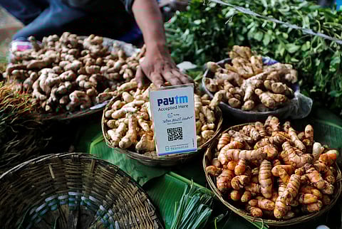 An advertisement board displaying a QR code for Paytm, a digital wallet company, is seen placed amidst vegetables at a roadside vendor's stall in Mumbai (File photo| Reuters)