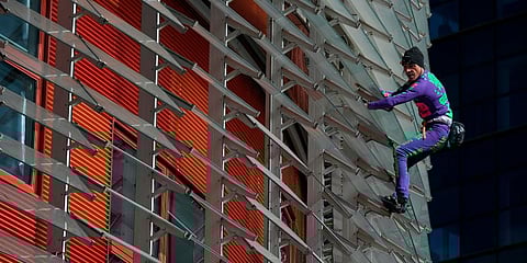 French skyscraper climber Alain Robert, known as the French Spiderman, climbs the Agbar Tower in Barcelona on March 4, 2020 as a symbolic action to call on governments and individuals across the world to be more responsible in the face of the COVID-19 cor