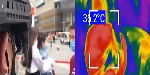 The video shows the officers looking around to screen passing shoppers to see if their body temperatures were above 37.3 degrees Celsius. (Photo |  PD China Twitter)