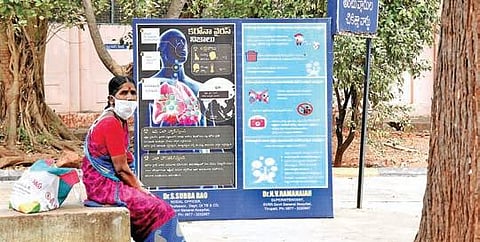 A woman with a mask sits under the shade of a tree at Ruia government hospital  in Tirupati on Saturday. (Photo| Madhav K, EPS)