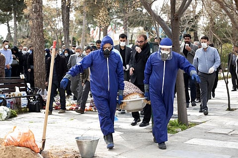 Men wearing protective gear carry the body of Fatemeh Rahbar, a lawmaker-elect from a Tehran constituency, who died on Saturday after being infected by COVID-19 at Behesht-e-Zahra cemetery. (Photo | AP)