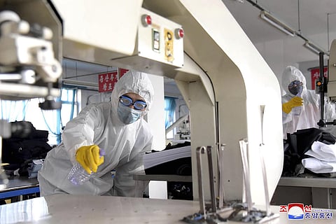 In this undated photo provided released on Wednesday, March 4, 2020, by the North Korean government, workers wearing protective suits spray disinfectant as a precaution against the new coronavirus at a garment factory in Pyongyang, North Korea. (Photo | A