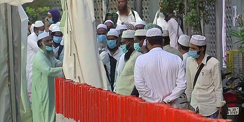 People from Markaz building wear a protective mask as they walk to board a bus that will be taken to the hospital amid concerns about the spread of coronavirus disease (COVID-19) at Nizamuddin Area in New Delhi. (Photo| ANI)