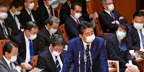 Japanese Prime Minister Shinzo Abe, wearing a face mask addresses lawmakers at the parliament's upper house in Tokyo. (Photo | AP)