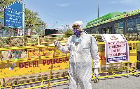 A policeman stands guard near Nizamuddin area wearing a protective suit (Photo | PTI)