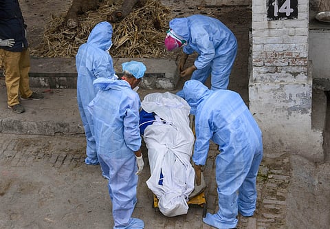Medics prepare to cremate a COVID-19 patient during the nationwide lockdown to curb the spread of coronavirus. (Photo | PTI)