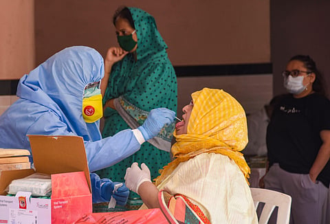 A healthcare worker collects swab sample of a person for COVID-19 test during the nationwide lockdown. (Photo | PTI)