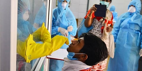 Health workers take nasal swabs from a person through a Covid-19 sample collection kiosk in Chennai. (Photo | Debdatta Mallick, EPS)