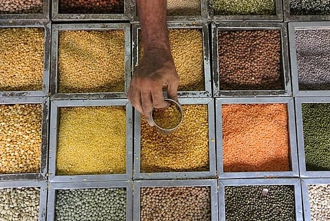 An employee collects lentils from a container inside a grocery store. (File | Reuters)