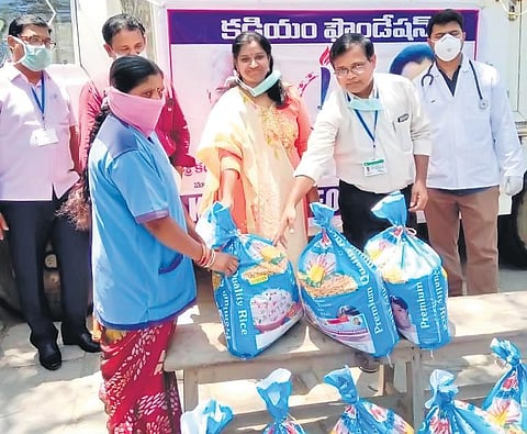 Dr Kadiyam Kavya, a pathologist at Community Health Centre of Wardhannapet in Warangal rural district, distributes groceries to sanitation workers on Saturday. (Photo | EPS)