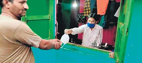 Bhagaban Tanti giving away mask to a villager I Express