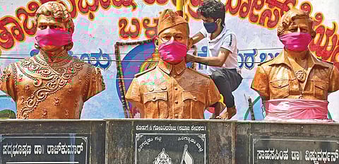 In a bid to spread awareness on safety, workers tie face masks on to the busts of Kannada matinee icon Rajkumar, Netaji Subhash Chandra Bose and late actor Dr Vishnuvardhan on Pampa Mahakavi Road, Bengaluru, on Saturday I Shriram BN