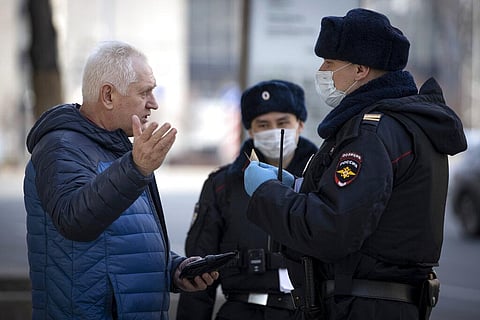 Russian police officers, wearing face masks to protect from coronavirus, check documents of a man to ensure a self-isolation regime due to coronavirus, in Moscow, Russia, Monday, April 13, 2020. (Photo | AP)