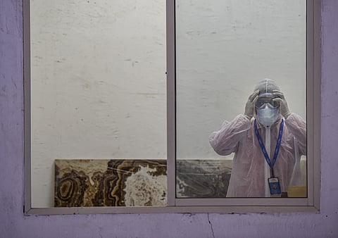 A medic wears a protective suit in the waiting room of the first drive-through sample collection site for possible COVID-19 patients during the nationwide lockdown to curb the spread of coronavirus at Lower Parel in Mumbai. (Photo | PTI)