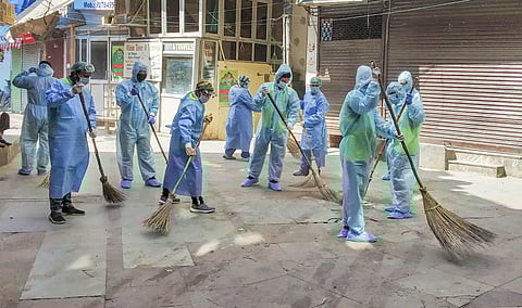 South Delhi Municipal Corporation workers wearing protective suits clean the Nizamuddin residential area in wake of the coronavirus pandemic during the nationwide lockdown in New Delhi. (Photo | PTI)