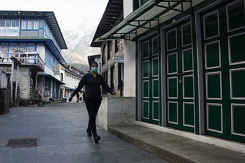 A Nepalese woman steps out of her house wearing a mask. (Photo| AFP)