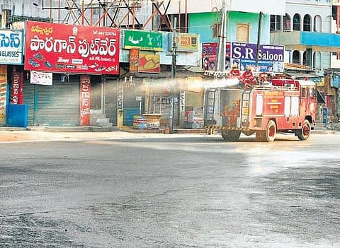 Firefighters spray disinfectant on roads in Guntur city on Monday. (Photo | EPS)