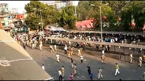 A snapshot of migrant workers out on the streets in Bandra, police are seen trying to disband the mob. (Screenshot | Express)
