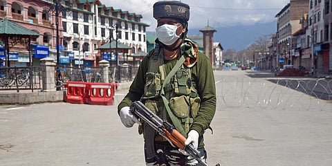 A CRPF personnel wearing a facemask stands guard during a nationwide lockdown as a preventive measure against the COVID-19 coronavirus, in Srinagar. (Photo| ANI)