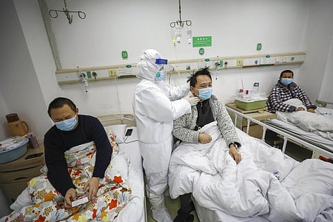 In this Feb. 13, 2020, photo, a doctor checks the conditions of a patient in Jinyintan Hospital, designated for critical COVID-19 patients, in Wuhan. (Photo | AP)