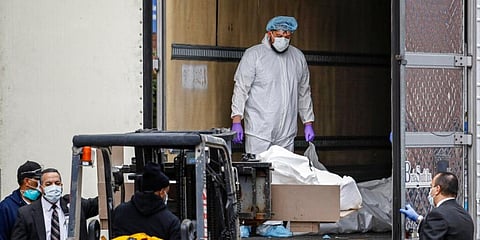 A body is loaded onto a refrigerated container truck used as a temporary morgue by medical workers at Brooklyn Hospital Center, New York. (Photo | AP)
