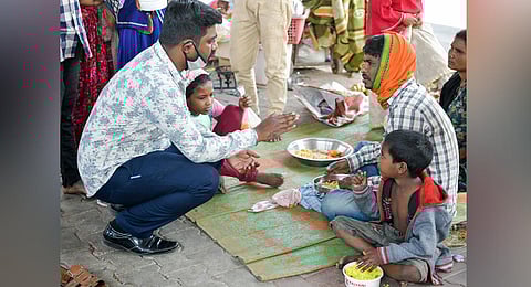 BBMP marshals talk to homeless people about sanitising their hands before they board a government bus that will take them to temporary shelters in Bengaluru on Monday. They began moving homeless people to shelters last Friday. (Photo | Meghana Sastry, EPS