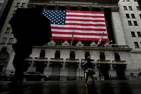 A woman walks past the New York Stock Exchange. (Photo| AFP)