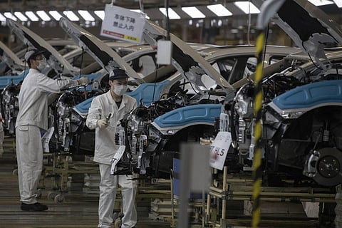 In this April 8, 2020, photo, employees work on a car assembly line at the Dongfeng Honda Automobile Co., Ltd factory in Wuhan in central China's Hubei province. Chinese leaders have reopened factories and shops in an effort to revive the economy, but the